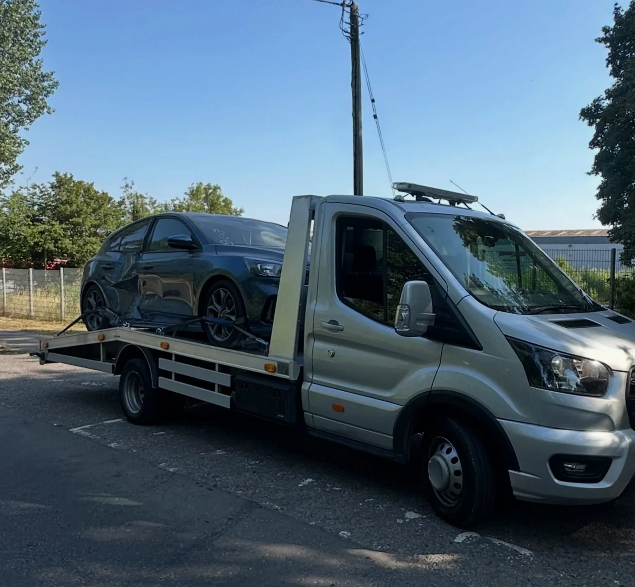 Damaged vehicle securely loaded onto Morley and Sons recovery truck